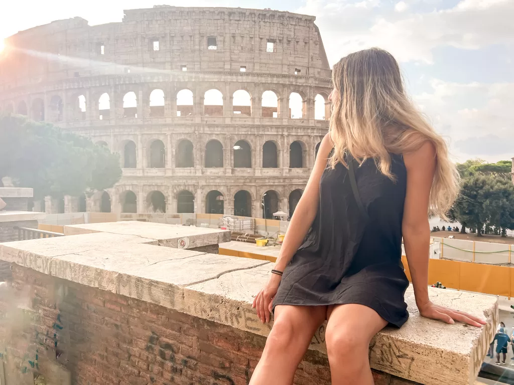 Sitting on a ledge looking at the Colosseum from across the road. 