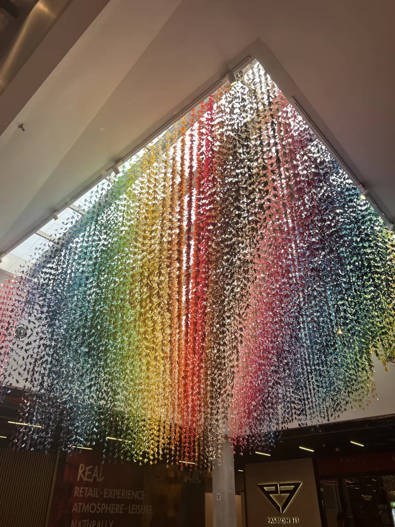 rainbow paper crane art installation in the shopping center